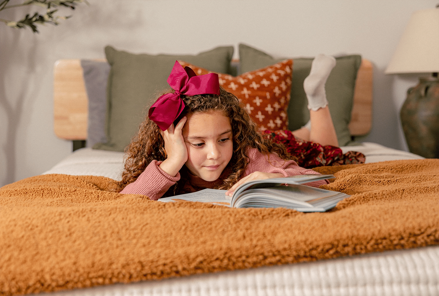 Girl laying in bed reading