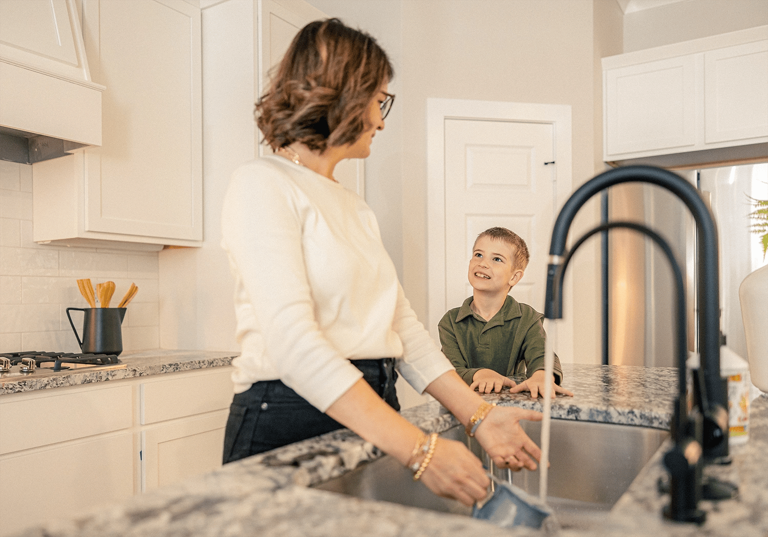 Mother washing dishes with her son