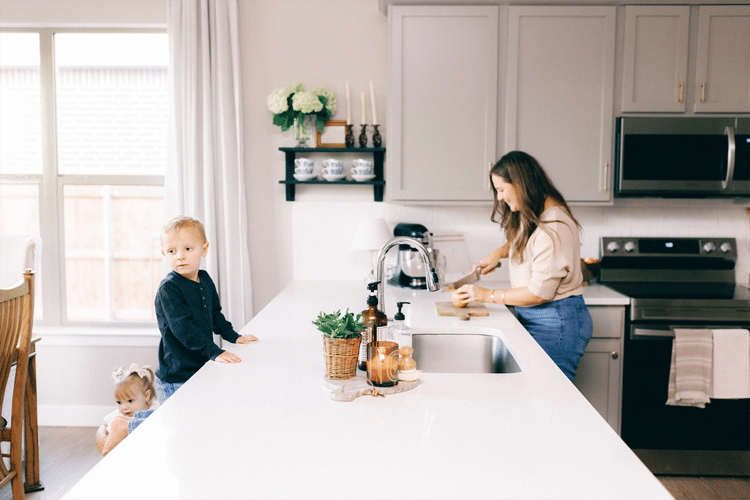 Mother cooking in kitchen with her young children