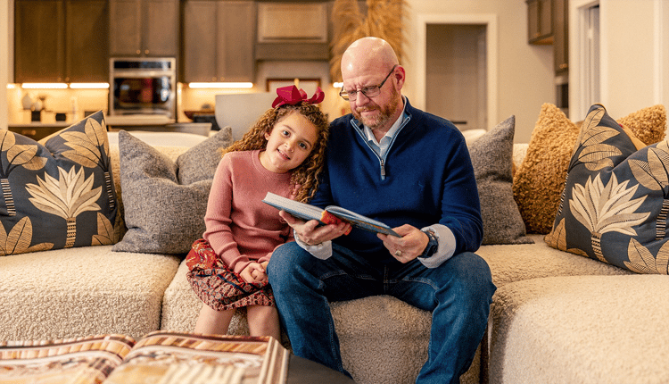 Father and his daughter reading on couch