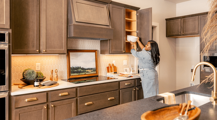 Woman putting away dishes in kitchen