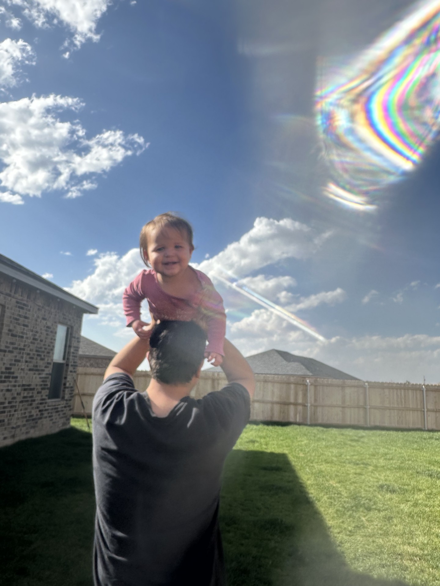 Photo of Gabe playing with his daughter in the back yard of their Betenbough home.