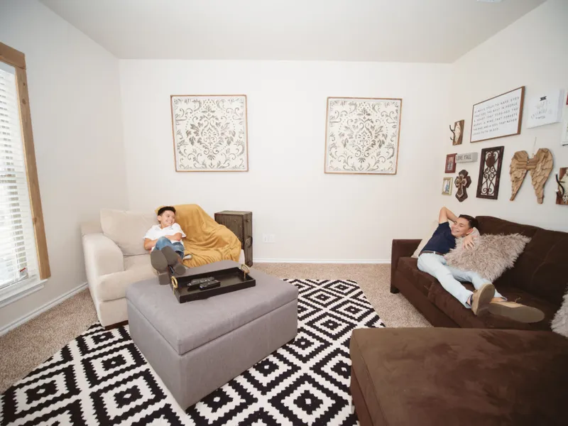 Photo of two boys relaxing in the decorated and furnished living room of a Betenbough home.