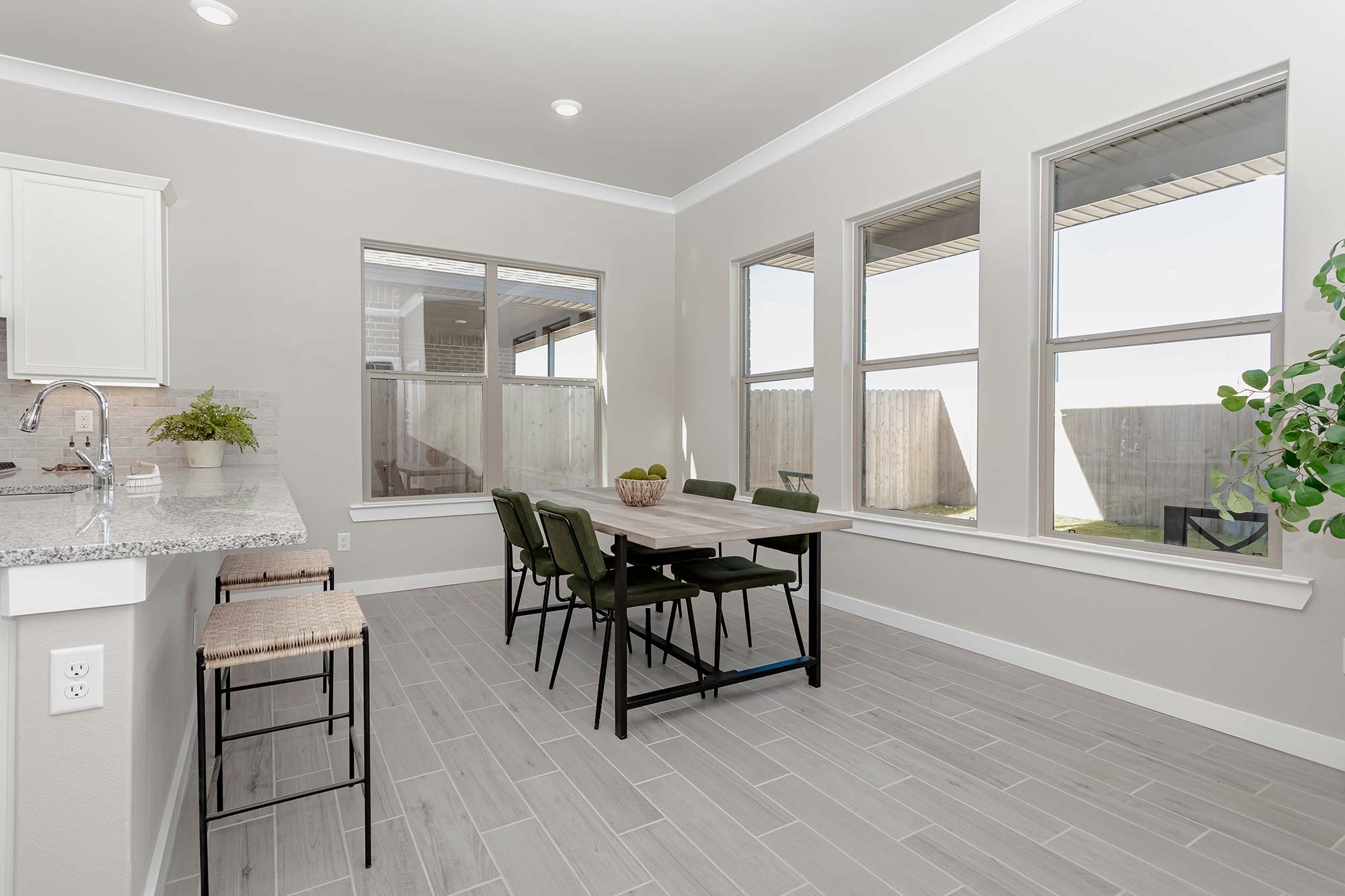 Rendering of a dining table with green chairs in a Betenbough home dining room.