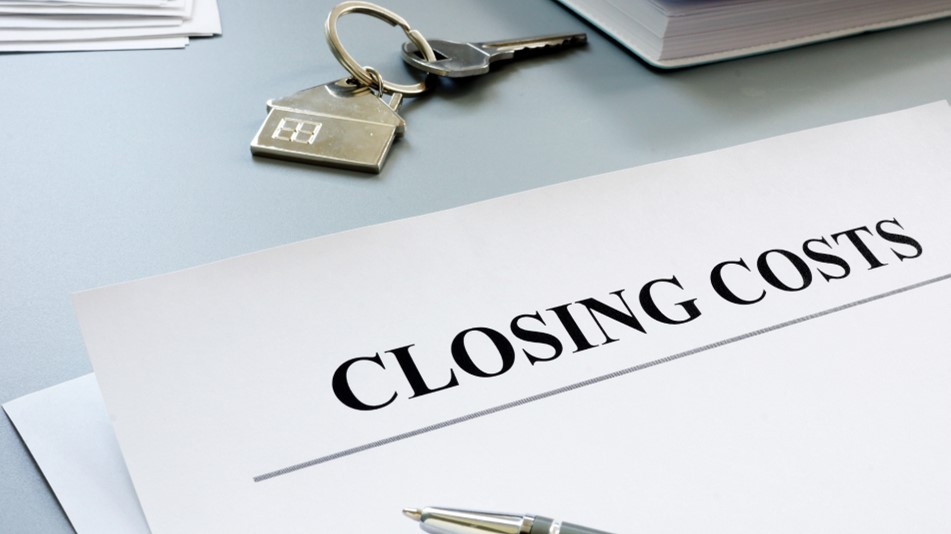 Photo of a piece of paper titled 'Closing Costs' on a desk with a house key, representing using your tax return to help pay closing costs when purchasing a new home.