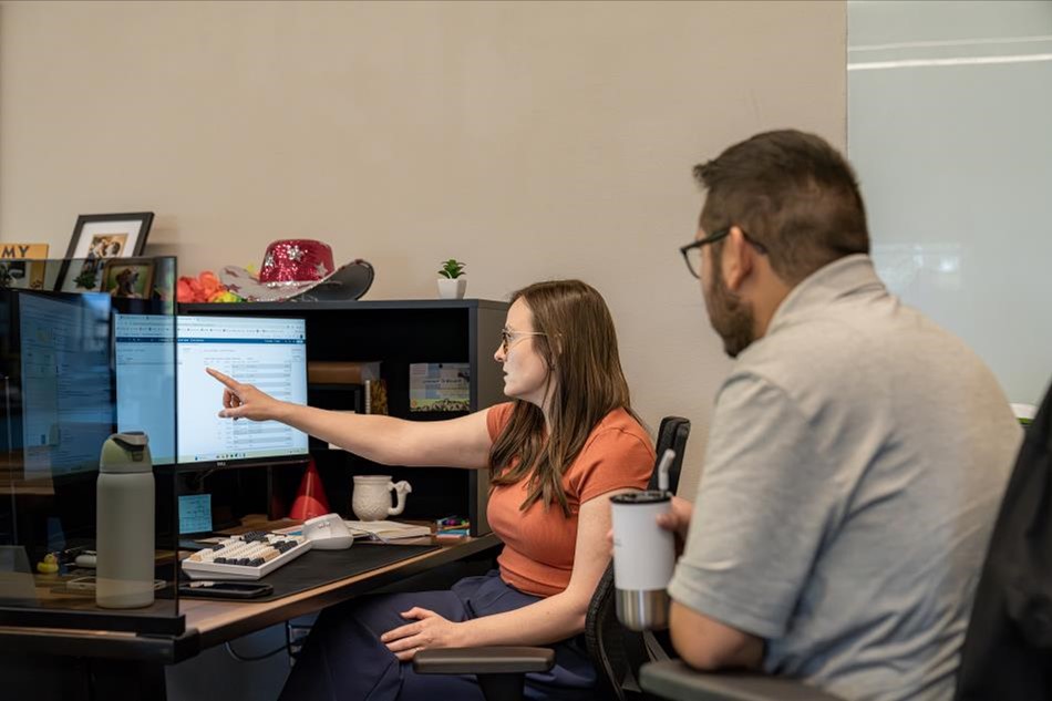 Photo of a man and woman looking at a computer screen to represent reviewing your credit report.