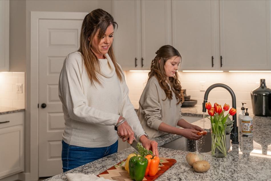 Photo of a mother and daughter preparing a meal in the kitchen of their Betenbough home.