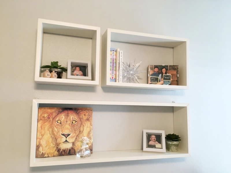 Photo of a vintage dresser being used as a changing table. Floating shelves are hung above.