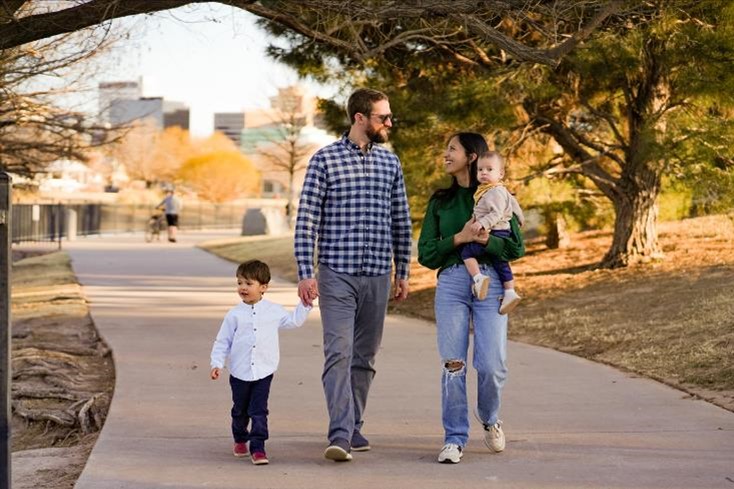 Photo of family walking on trail in their community representing that walking trails are sometimes an amenity provided by communities with an HOA.