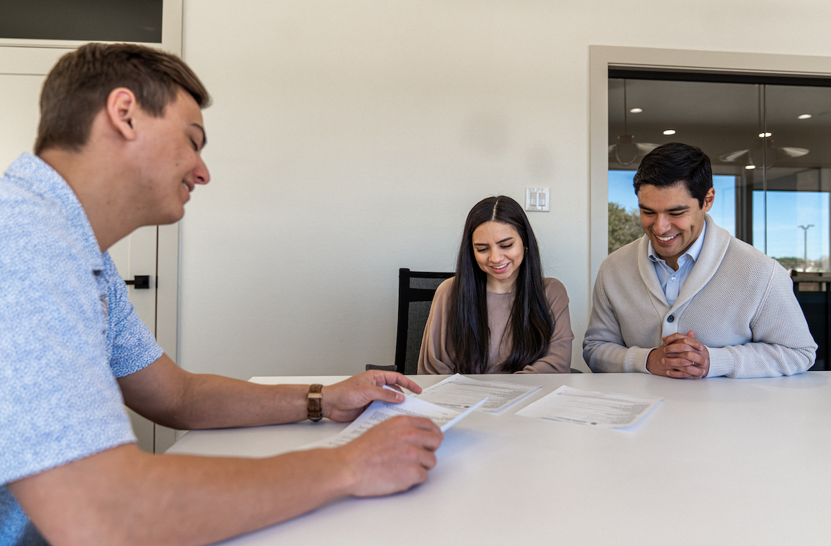 Photo of a Betenbough Homes sales manager meeting with home buyers.