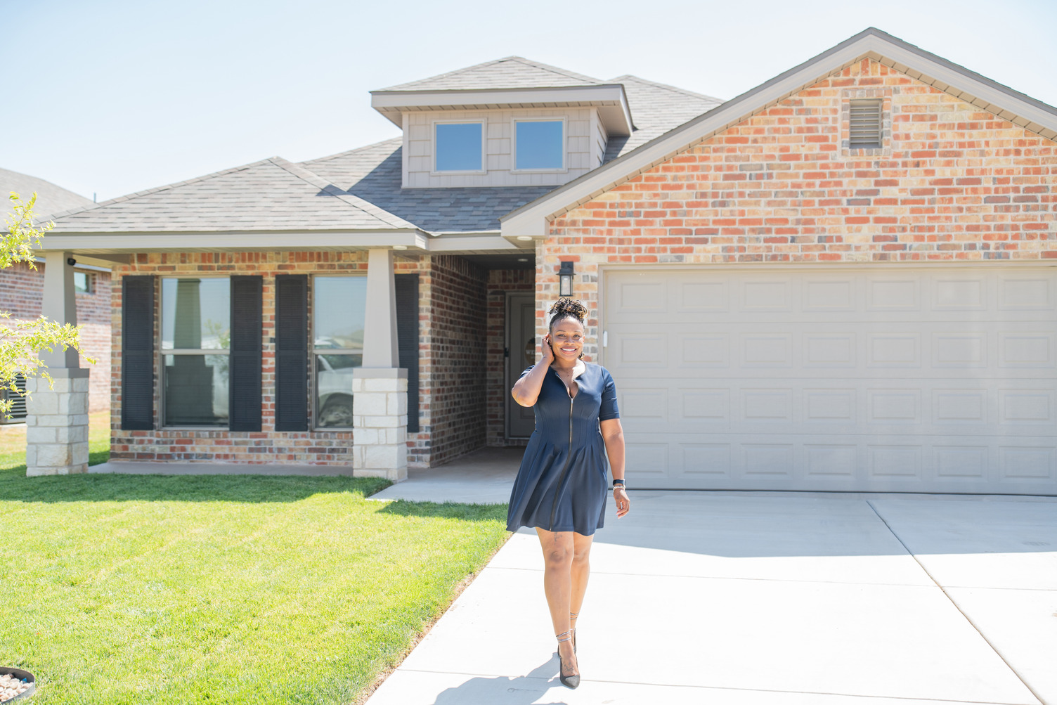 Happy woman standing in front of her new house