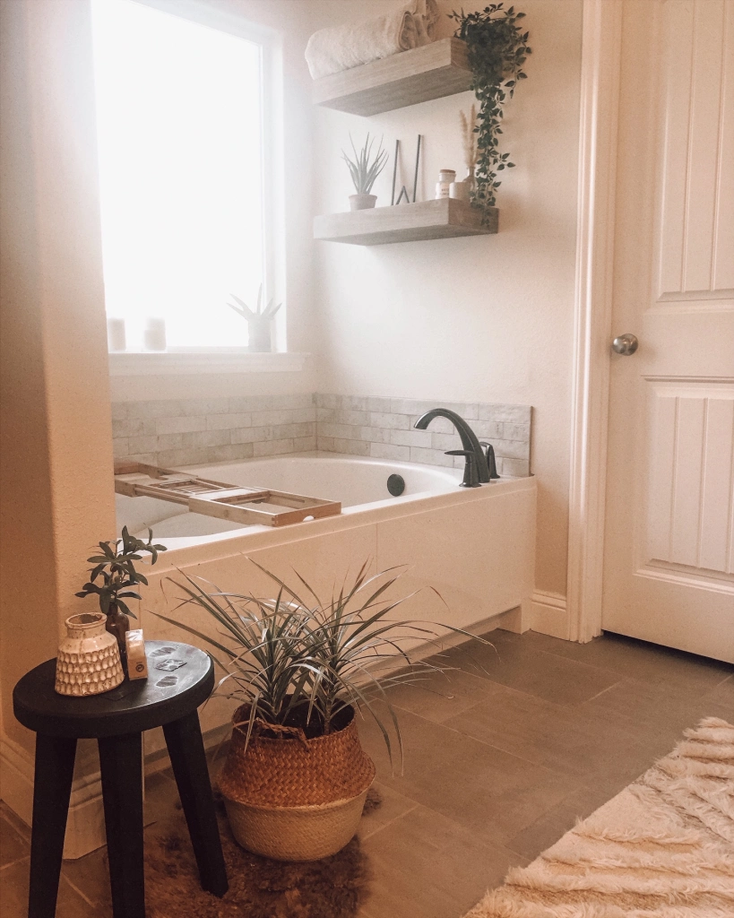 Photo of a bathroom decorated with floating shelves, plants, and candles.