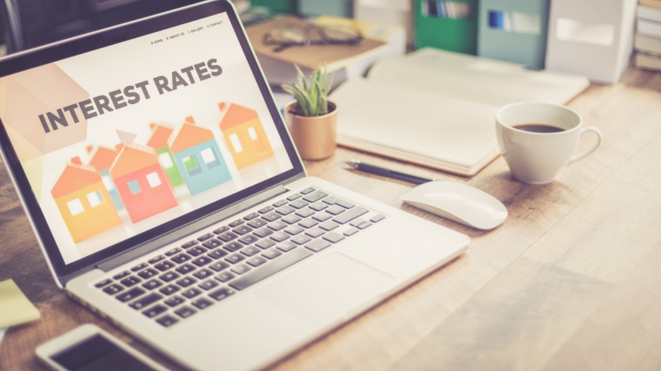 Photo of a laptop on a desk with a screen that says 'Interest Rates,' representing using your tax return to get a better interest rate on a home loan.