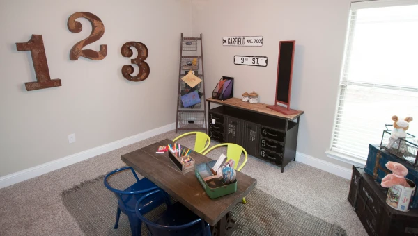 Photo of a table and chairs in the center of a kid's playroom.