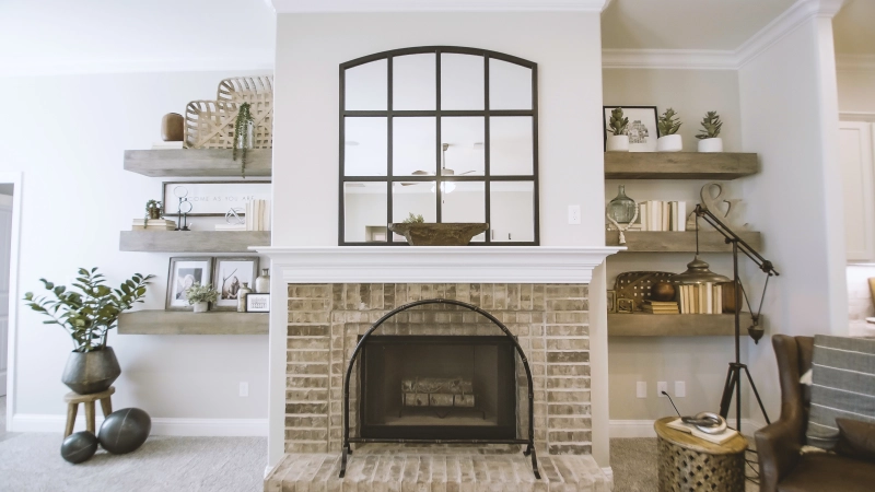 Photo of a decorated fireplace mantle and bookshelves in a new model home.