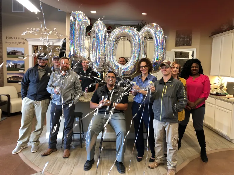 Photo of the Midland Betenbough Homes team celebrating 1,000 closings with streamers.