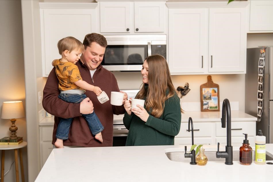 Photo of a family enjoying hot beverages in the kitchen of their Betenbough home kitchen.