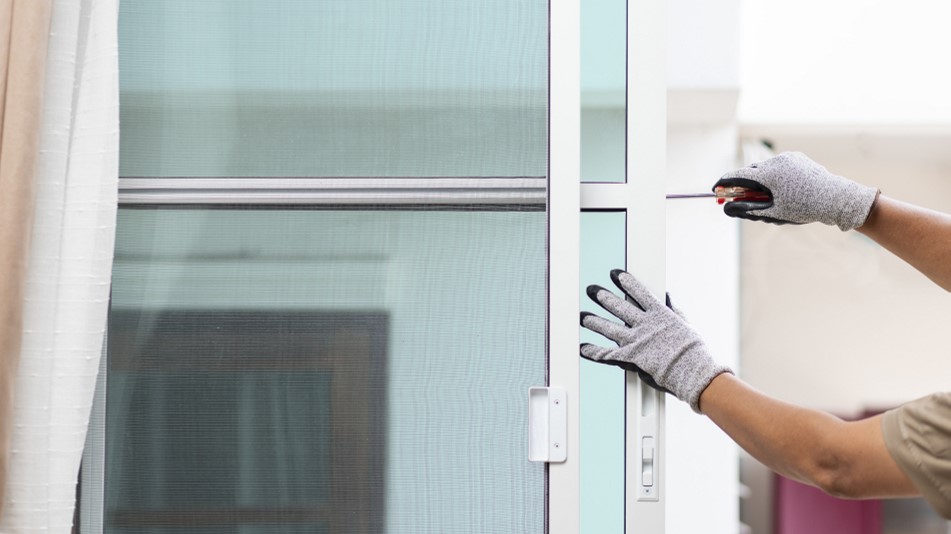 Photo of a man repairing a sliding glass door, representing using your down payment to make repairs to get your current home ready to sell.