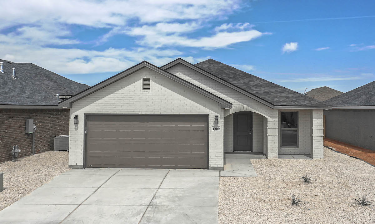 Photo of the exterior of Betenbough Homes' Victoria floor plan. This cottage-style home has a brick and vinyl exterior, large dormer, and covered front entry.