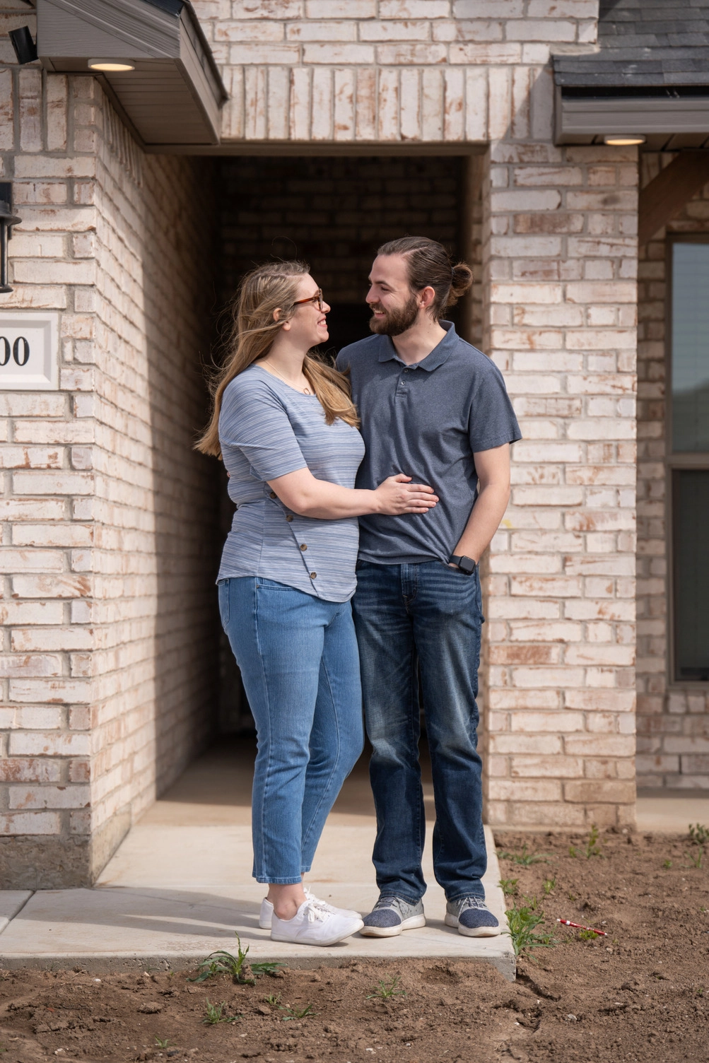 Young couple standing in front of their newly purchased Lubbock Betenbough Home